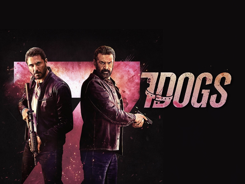 Two men in leather jackets holding guns, back-to-back, in a dark action-poster with a pink logo reading 'DOGS' in the background.