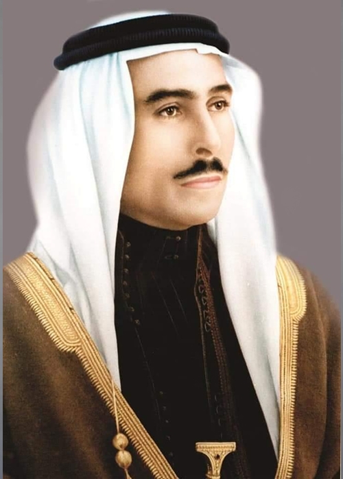 Portrait of a man in traditional Arab attire: white ghutra with black agal and brown bisht with gold trim.