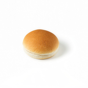 Round bread bun with a smooth golden crust on a white background