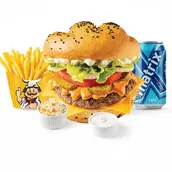 Sesame seed hamburger with lettuce and cheese, a side of french fries, dipping sauces, and a blue canned drink on a white background.