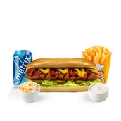 Hot dog with lettuce and tomato, served with blue potato chips, a small cup of coleslaw, and a dipping sauce on a white counter.